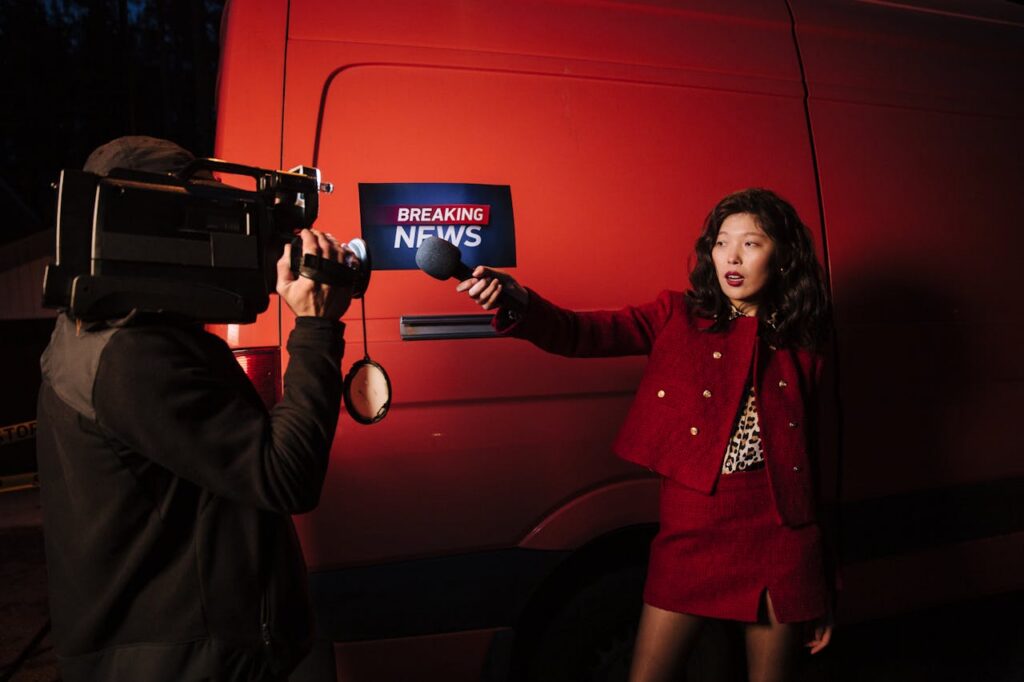 The Art of Drawing Readers In: Your attractive post title goes here Asian female reporter with cameraman conducting a nighttime news broadcast beside a news van.